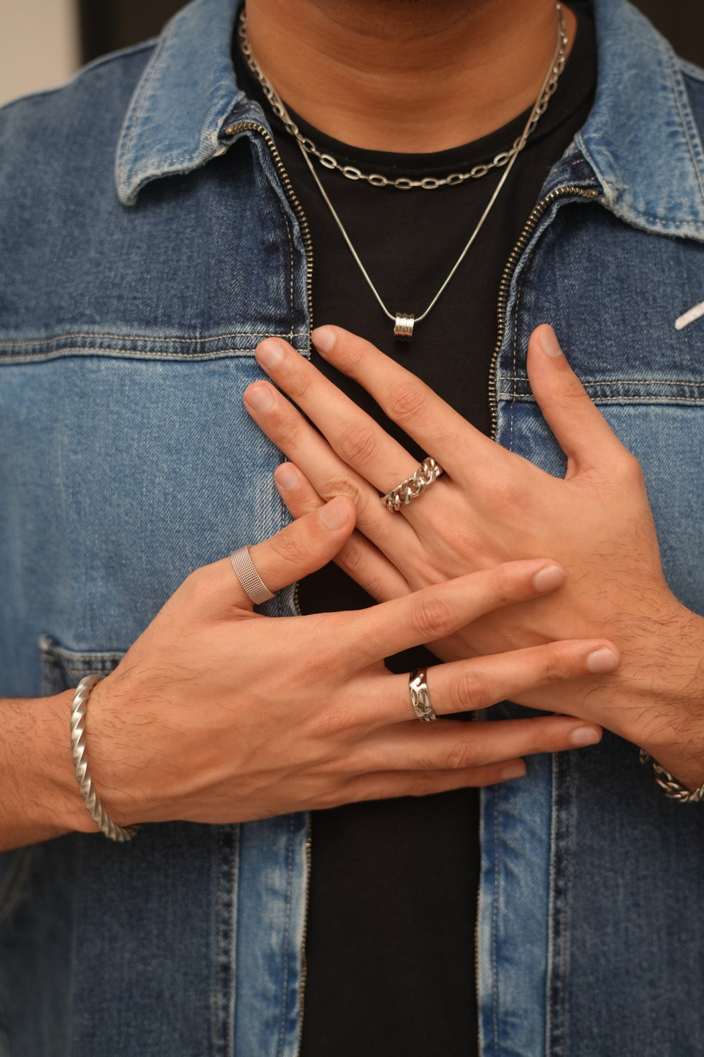 Close-up of hands with rings and a denim jacket